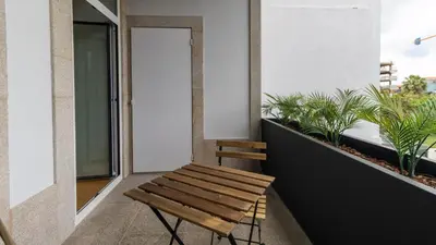 a wooden bench sitting on a balcony with plants at Almada 551 by LovelyStay in Porto