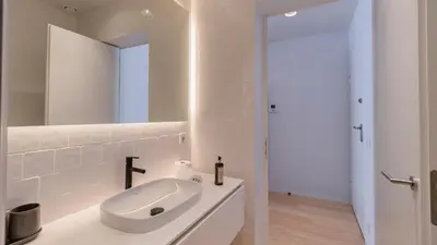a white bathroom with a sink and a mirror at Almada 551 by LovelyStay in Porto