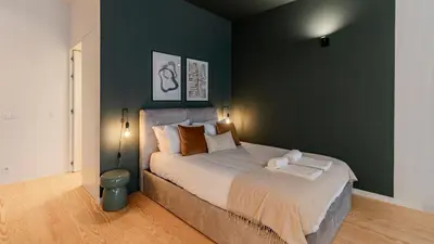 a bedroom with a large bed with a green wall at Almada 551 by LovelyStay in Porto