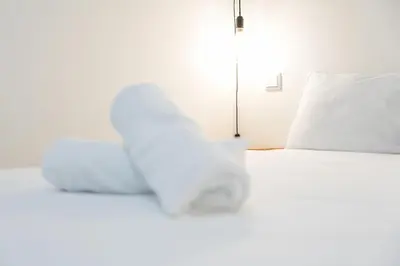 a white bed with white sheets and pillows at GuestReady - Breyner Stonewall Haven in Porto