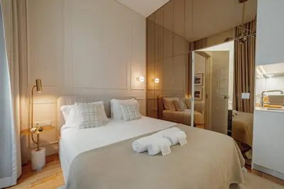 a bedroom with a large white bed with towels on it at Clerigos Boutique Apartments by Hosty in Porto