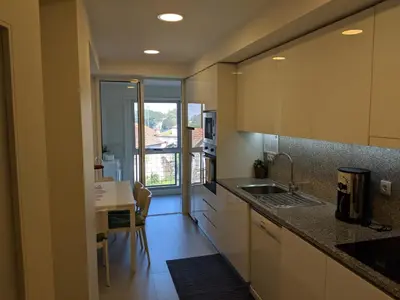 a kitchen with a sink and a table with a dining room at Apartamento em Monsanto - Porto in Porto