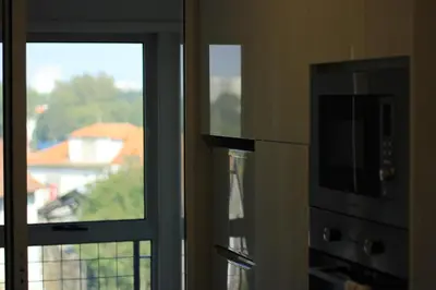 a kitchen with a microwave oven and a window at Apartamento em Monsanto - Porto in Porto