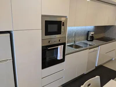 a kitchen with a microwave oven and a sink at Apartamento em Monsanto - Porto in Porto