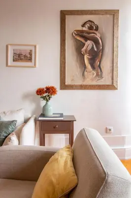 a living room with a couch and a painting on the wall at Porto 61 - Bright 2BR w/ Balcony by LovelyStay in Porto