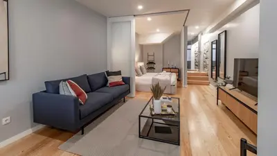 a living room with a blue couch and a tv at Belomonte 103 by LovelyStay in Porto