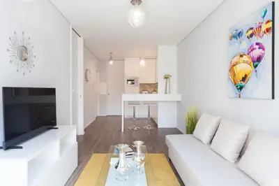a living room with a white couch and a tv at Urban Views - ML Apart Inspired by Palácio de Cristal in Porto