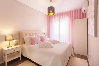 a bedroom with a white bed and pink curtains at Urban Views - ML inspired by Torre dos Clérigos in Porto