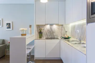 a white kitchen with white cabinets and a sink at Urban Views - ML inspired by Torre dos Clérigos in Porto