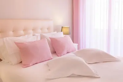 a white bed with pink pillows and a window at Urban Views - ML inspired by Torre dos Clérigos in Porto