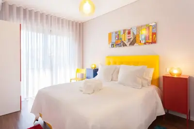 a bedroom with a white bed with a yellow headboard at Urban Views - ML Apart Inspired in Serralves in Porto