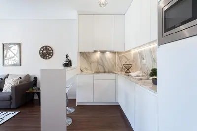 a kitchen with white cabinets and a couch at Urban Views - ML 2Bed Apart Inspired by Casa da Música in Porto