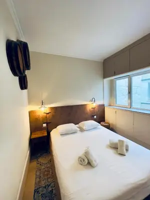 a bedroom with a large white bed with towels on it at Stylish Flat City Center in Porto