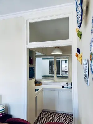 a kitchen with white cabinets and a window at Stylish Flat City Center in Porto