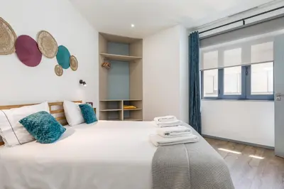 a bedroom with a large white bed and a window at Alma Bonfim Apartments in Porto