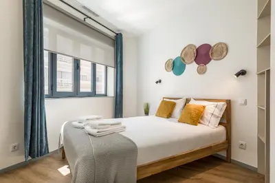 a bedroom with a bed and a window at Alma Bonfim Apartments in Porto