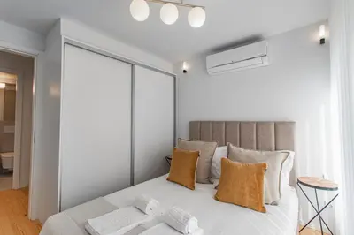 a bedroom with a large white bed with orange pillows at João das Regras 321 by LovelyStay in Porto