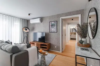 a living room with a couch and a television at João das Regras 321 by LovelyStay in Porto