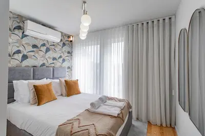 a bedroom with a bed and a large window at João das Regras 321 by LovelyStay in Porto