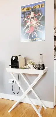 a white console table with a poster on the wall at Toctoc Studio in Porto