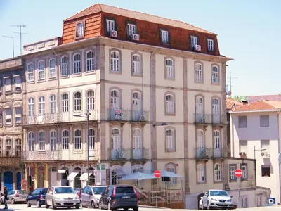 a large building with cars parked in front of it at Toctoc Studio in Porto