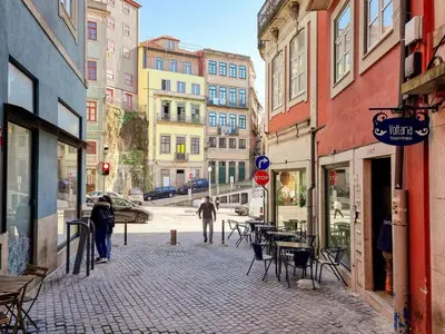 an old building with a large stone arch with parked cars at Inspiring City Center 1 BR Apartment with a View in Porto