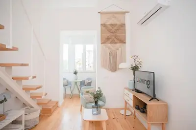 a living room with a couch and a table with a tv at Liiiving in Porto - Secret Grove Mezzanine in Porto