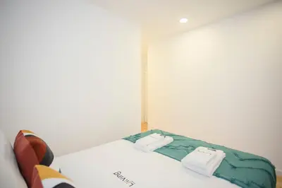 a white bed in a white room with a window at Liiiving in Porto - Secret Grove Mezzanine in Porto