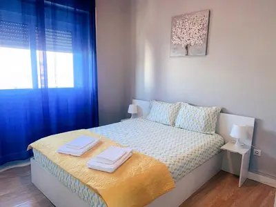 a bedroom with blue curtains and a bed with towels on it at Vicky Porto in Porto
