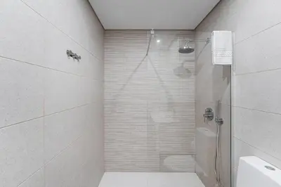 a white bathroom with a shower and a toilet at GuestReady - Casegas residence in Marquês in Porto