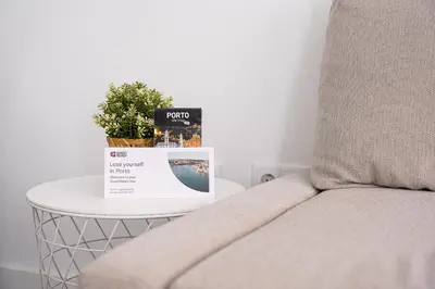 a table with a couch and a potted plant on it at GuestReady - Casegas residence in Marquês in Porto
