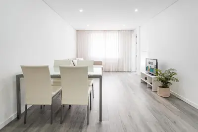 a dining room with a table and white chairs at GuestReady - Casegas residence in Marquês in Porto