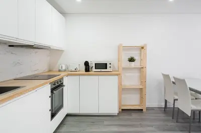a kitchen with white cabinets and white appliances at GuestReady - Casegas residence in Marquês in Porto