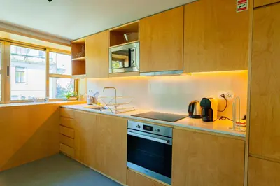 a kitchen with wooden cabinets and a stove top oven at Oporto City View - Guest House Suites in Porto