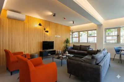 a living room with a couch and orange chairs at Oporto City View - Guest House Suites in Porto