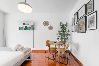 a room with a bed and a table and chairs at GuestReady - Portrait with a view in Porto