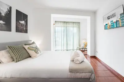 a bedroom with a large white bed with a window at GuestReady - Portrait with a view in Porto