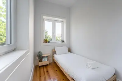 two beds in a room with two windows at GuestReady - The perfect haven near St. Catarina in Porto