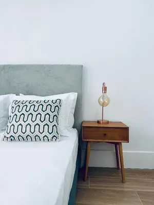 a bedroom with a bed and a nightstand with a lamp at Vibrant Host -Bonfim in Porto