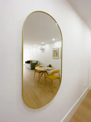 a mirror on a wall in a living room with a table at Vibrant Host -Bonfim in Porto