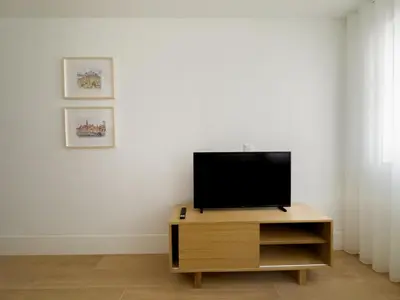 a television on a wooden stand in a living room at Vibrant Host -Bonfim in Porto