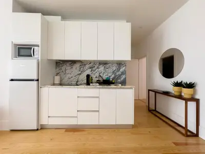 a kitchen with white cabinets and a refrigerator at Vibrant Host -Bonfim in Porto