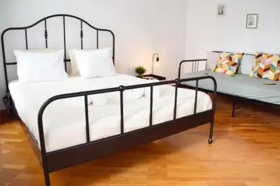 a black metal bed in a room with a couch at Goodgarden Downtown Apartment in Porto