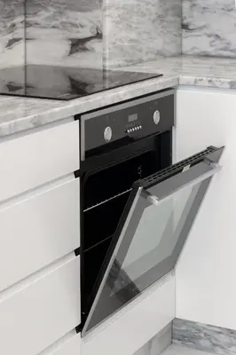 a black oven in a kitchen with white cabinets at HM - Ribeira Historical Apartment in Porto