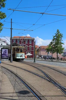 a trolley car on a street with a red building at HM - Ribeira Historical Apartment in Porto