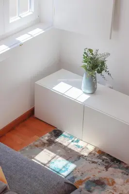 a white cabinet with a potted plant on top of it at HM - Ribeira Historical Apartment in Porto