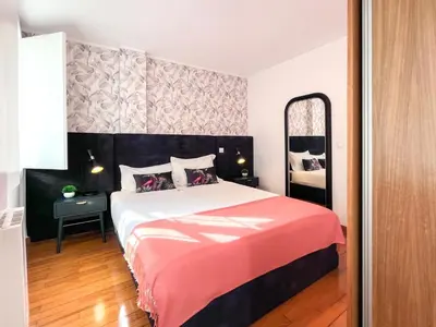a bedroom with a large bed and a mirror at HM - Ribeira Historical Apartment in Porto