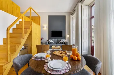 a dining room with a table and chairs and a staircase at WHome Central 1-Bed w/ Top View perfect to Explore Porto in Porto