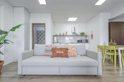 a living room with a couch with pillows on it at Travel & Live Fernão Magalhães in Porto