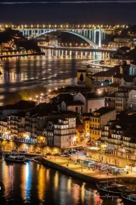 a view of a city at night with a bridge at Porto Apartments in Porto